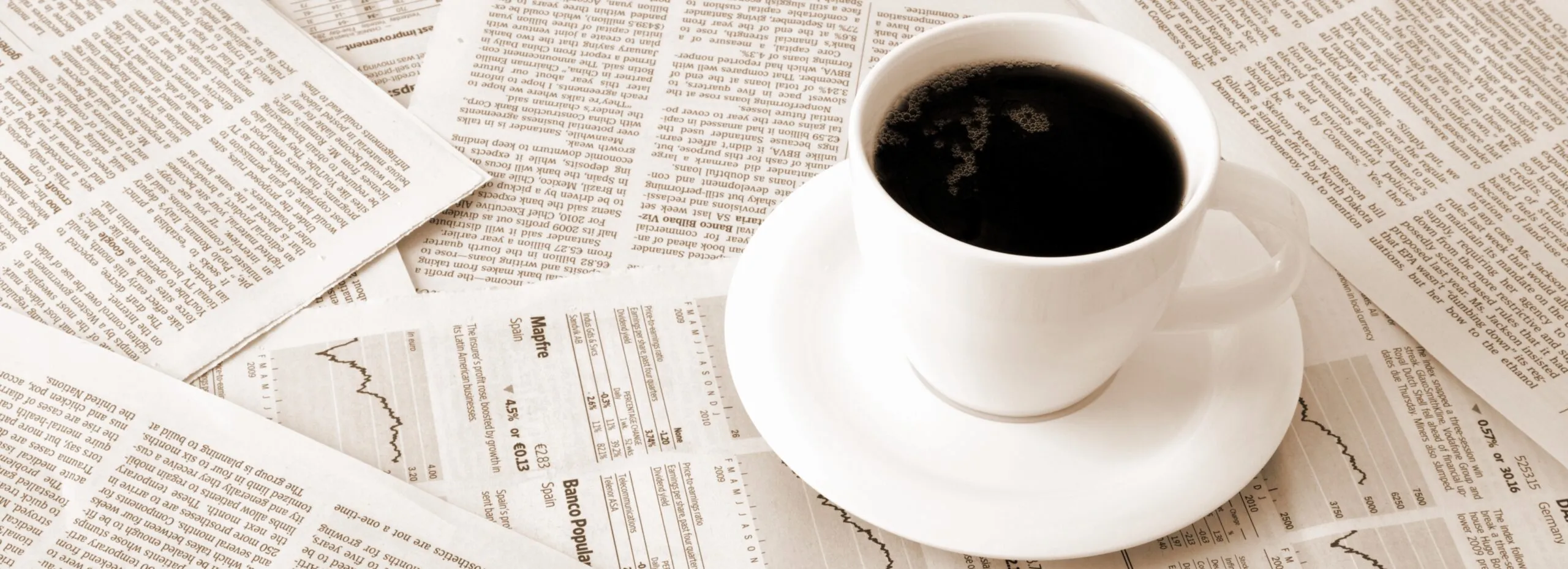 Cup of coffee sitting on article print outs